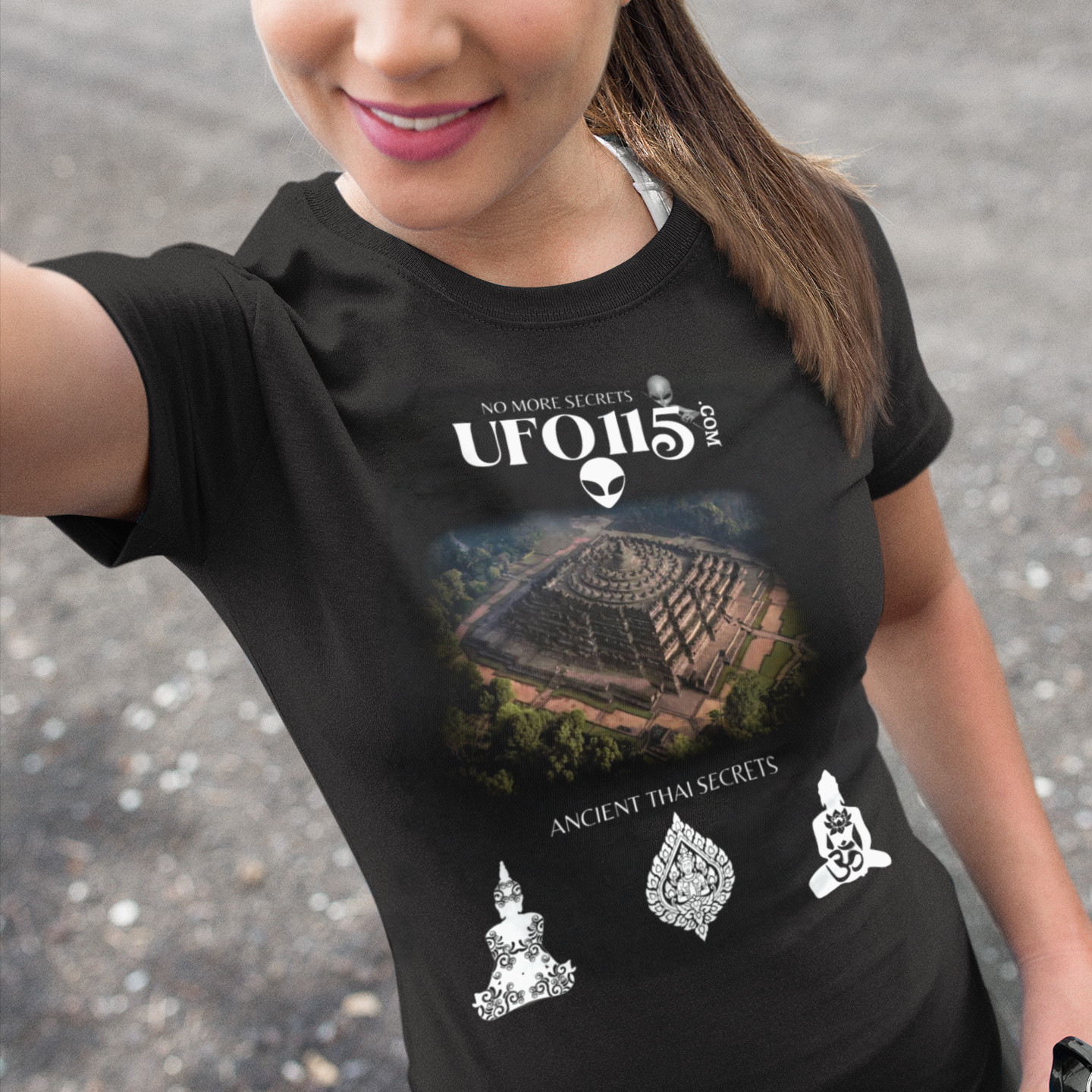 Ancient Thai Secrets T-shirt in Black, front print, worn by a model (outdoor selfie, day). AI-edited photo: the real print artwork was digitally placed on a model photo.
