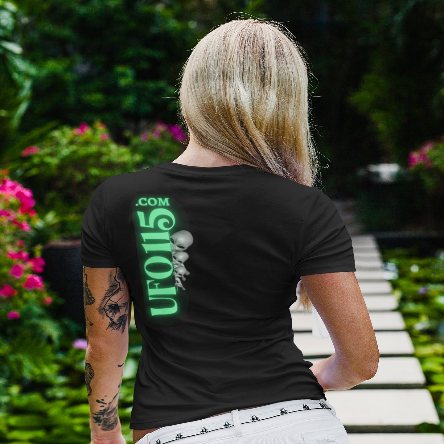 Element 115 Fuel Cell T-shirt in Black, back print, worn by a model (tropical garden walkway (back)). AI-edited photo: the real print artwork was digitally placed on a model photo.