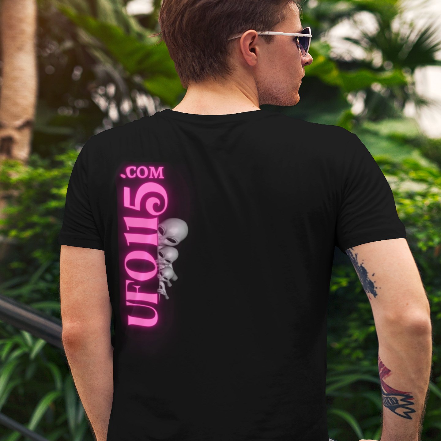 Have a Nice Day Mask T-shirt in Black, back print, worn by a model (tropical garden, day (back)). AI-edited photo: the real print artwork was digitally placed on a model photo.