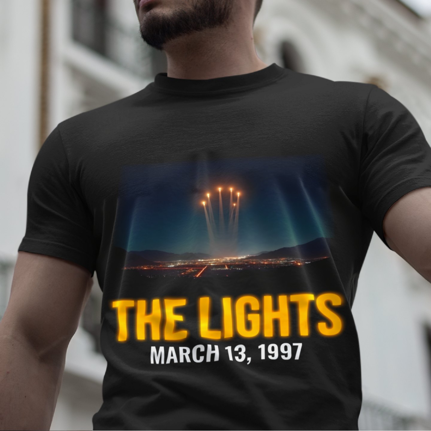 Lights Over the Desert 1997 T-shirt in Black, front print, worn by a model (classic architecture, day). AI-edited photo: the real print artwork was digitally placed on a model photo.