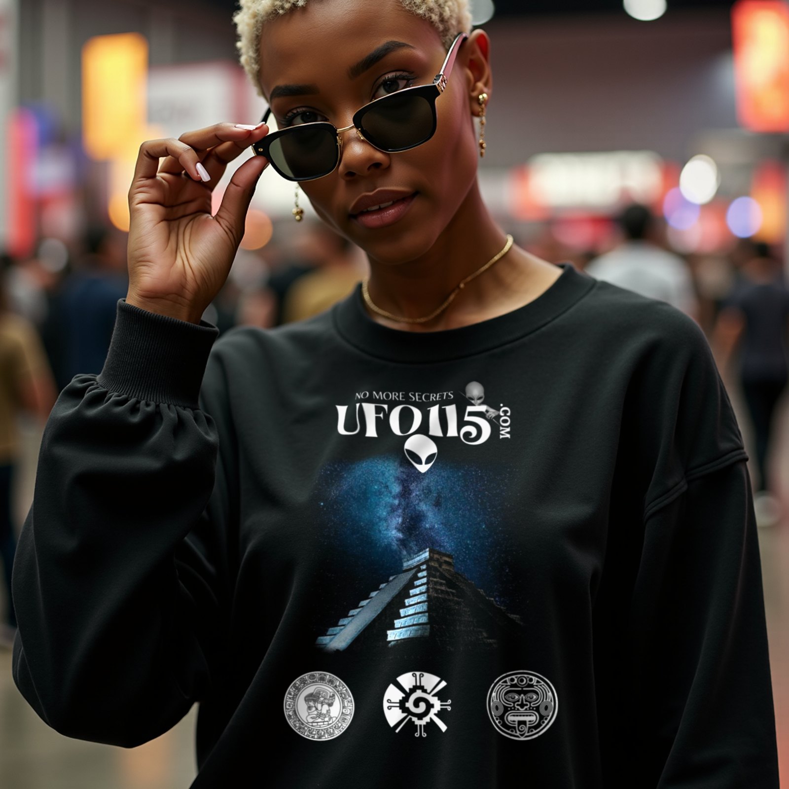 Mayan Pyramid Milky Way crewneck sweatshirt in Black, worn by a model (in a busy science-fiction fan convention hall). AI-generated image: model and scene are AI-generated; the print is the real artwork.