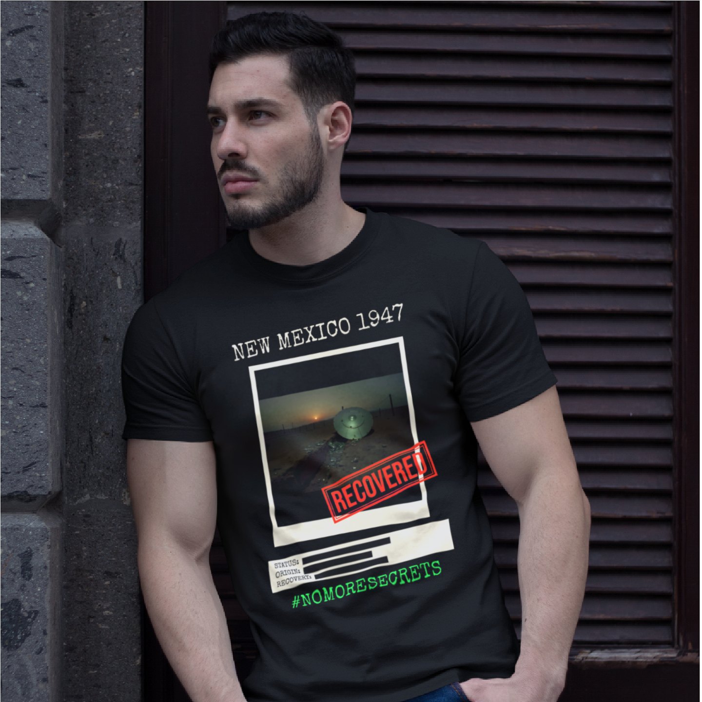 New Mexico 1947 Disc Recovered T-shirt in Black, front print, worn by a model (stone doorway, day). AI-edited photo: the real print artwork was digitally placed on a model photo.