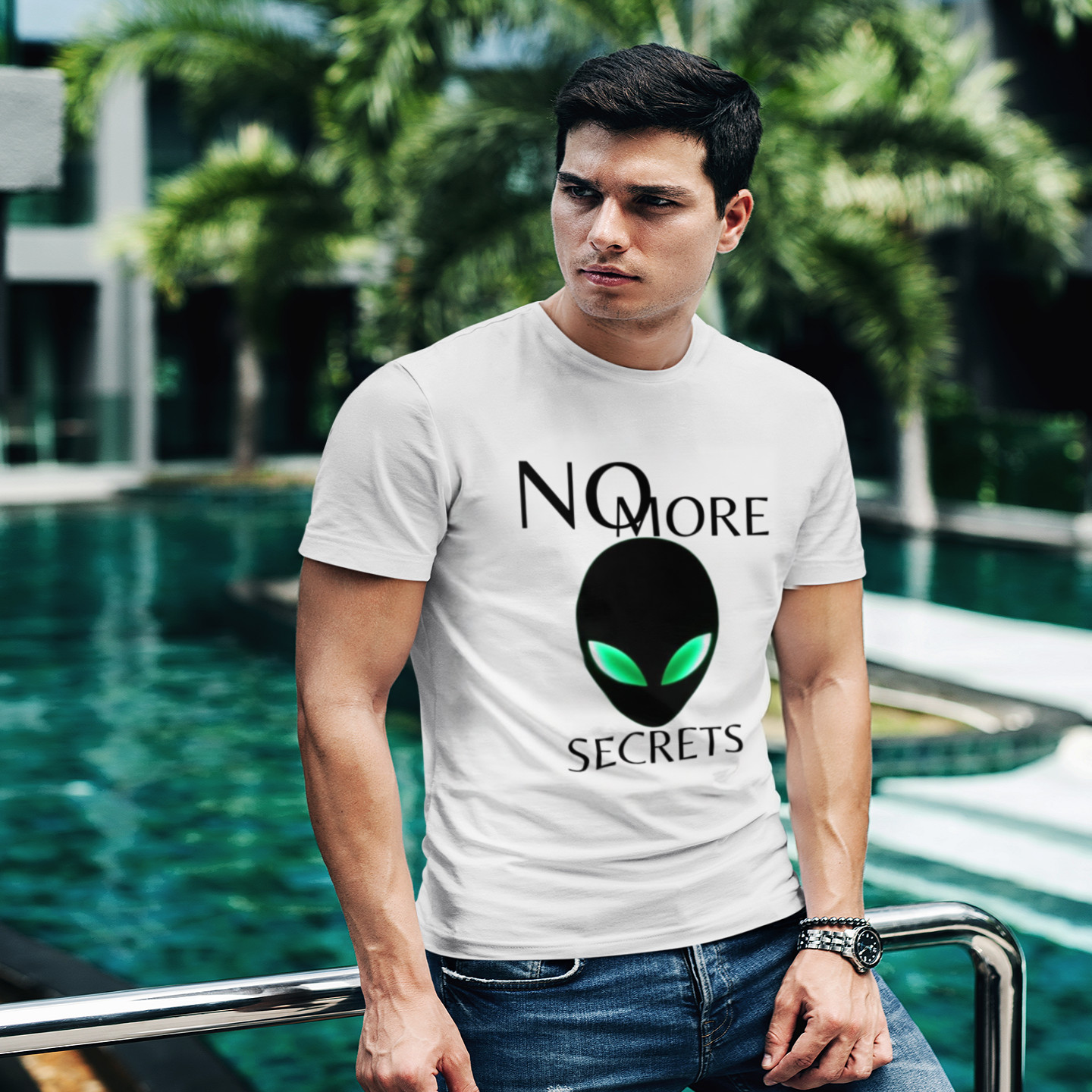 No More Secrets Alien Face T-shirt in White, front print, worn by a model (tropical pool, day). AI-edited photo: the real print artwork was digitally placed on a model photo.