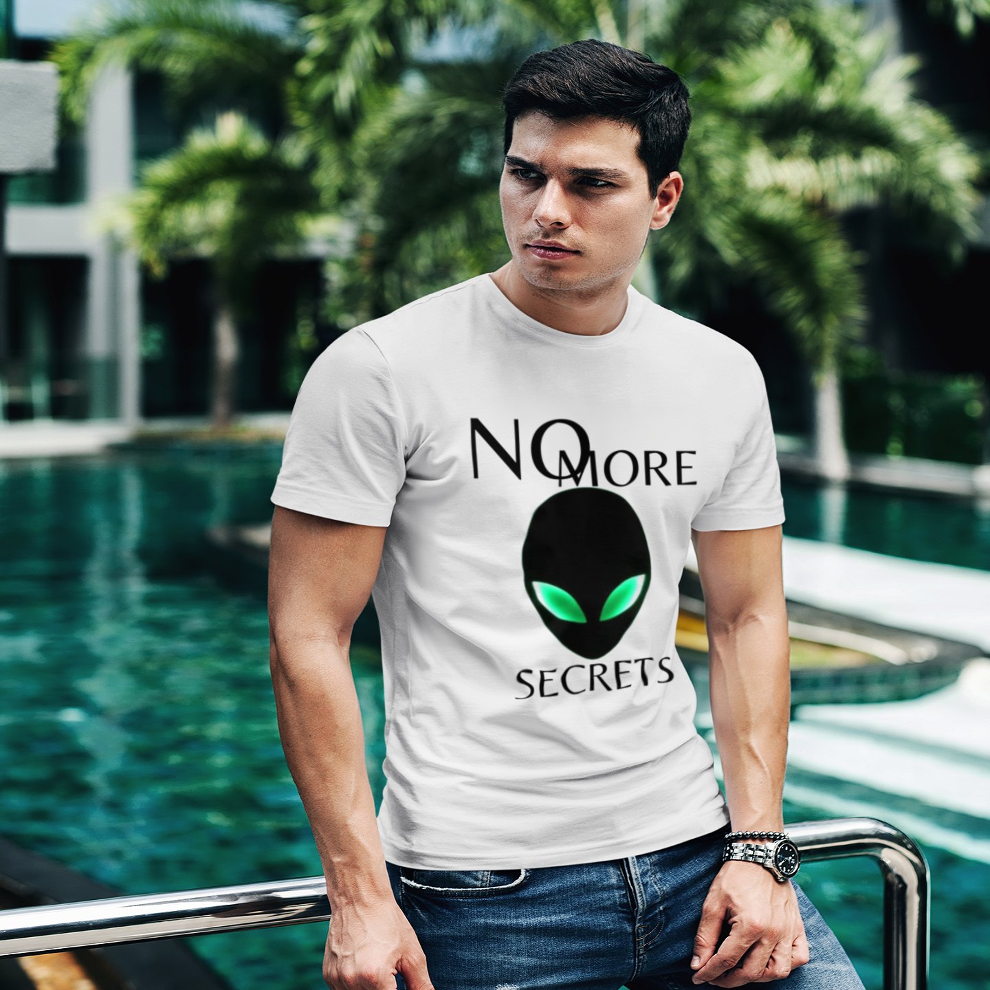 No More Secrets Alien Face T-shirt in White, front print, worn by a model (tropical pool, day). AI-edited photo: the real print artwork was digitally placed on a model photo.