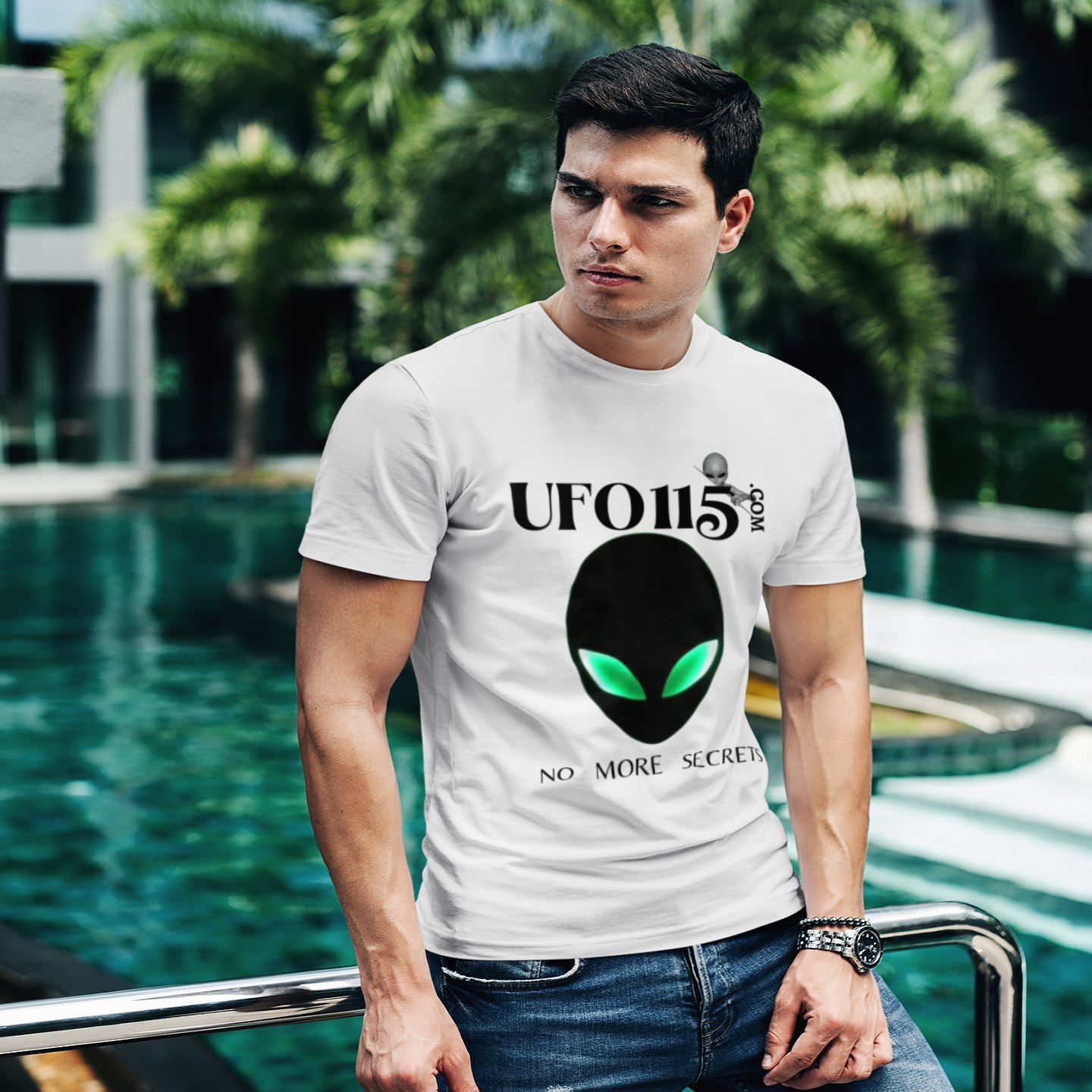 No More Secrets Green Eyes T-shirt in White, front print, worn by a model (tropical pool, day). AI-edited photo: the real print artwork was digitally placed on a model photo.