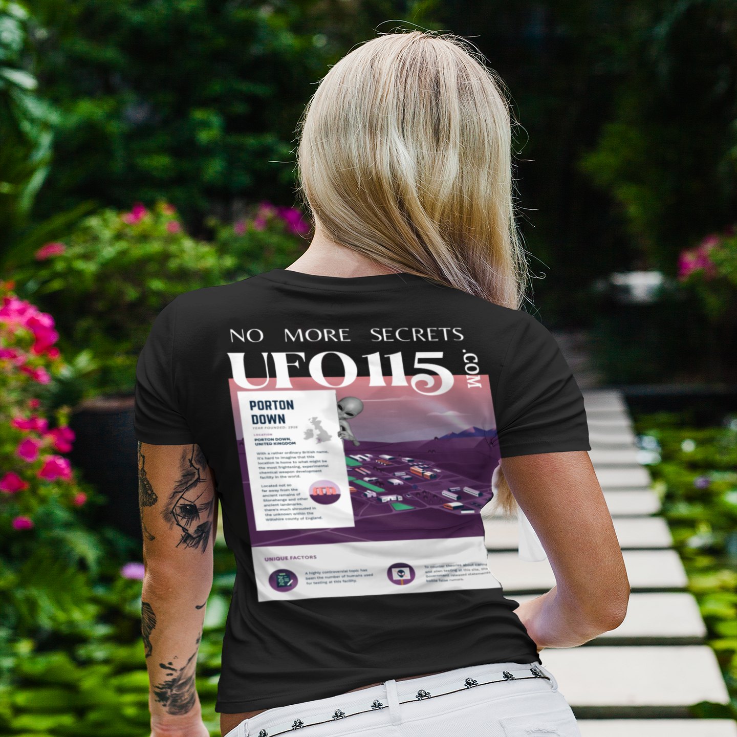 No More Secrets Porton Down T-shirt in Black, back print, worn by a model (tropical garden walkway (back)). AI-edited photo: the real print artwork was digitally placed on a model photo.