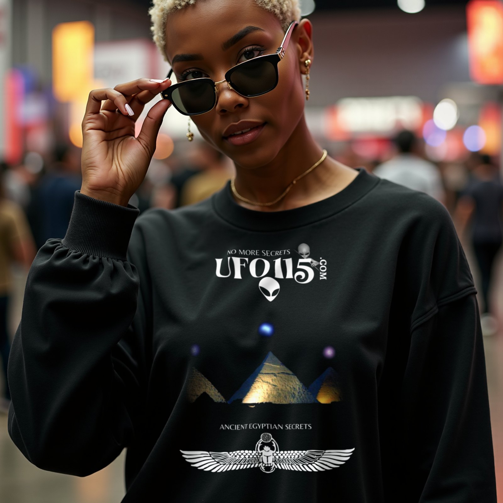 Orion's Belt Pyramids crewneck sweatshirt in Black, worn by a model (in a busy science-fiction fan convention hall). AI-generated image: model and scene are AI-generated; the print is the real artwork.
