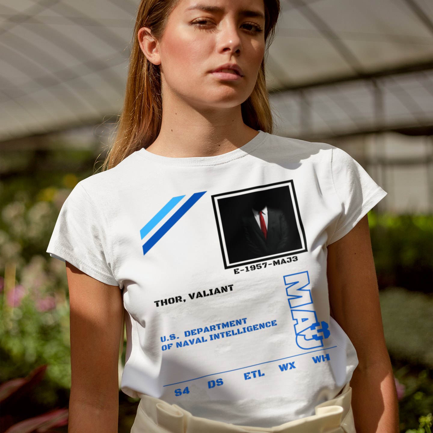 S4 ID Valiant Thor T-shirt in White, front print, worn by a model (greenhouse, day). AI-edited photo: the real print artwork was digitally placed on a model photo.