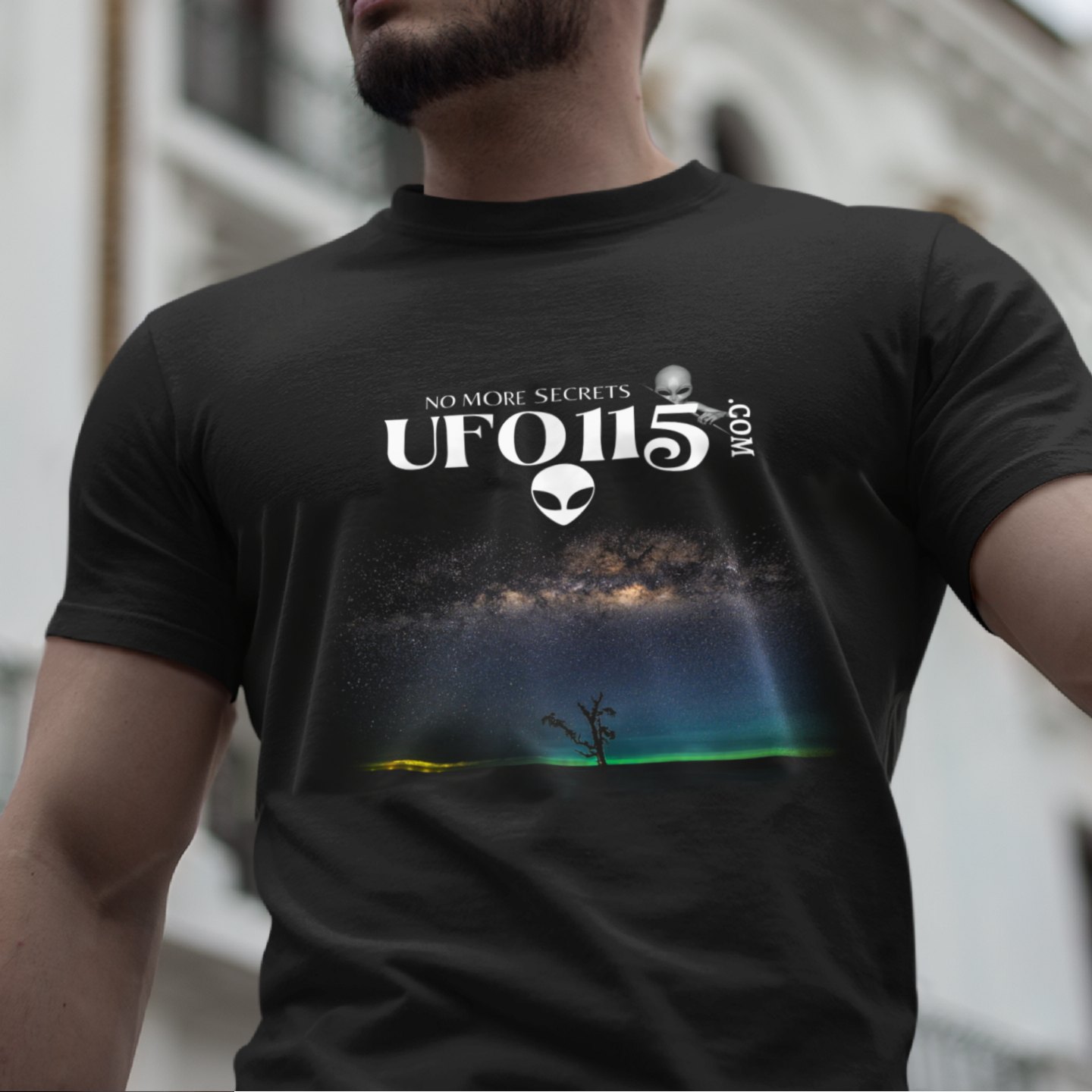 Sky Watcher Glowy Nights T-shirt in Black, front print, worn by a model (classic architecture, day). AI-edited photo: the real print artwork was digitally placed on a model photo.