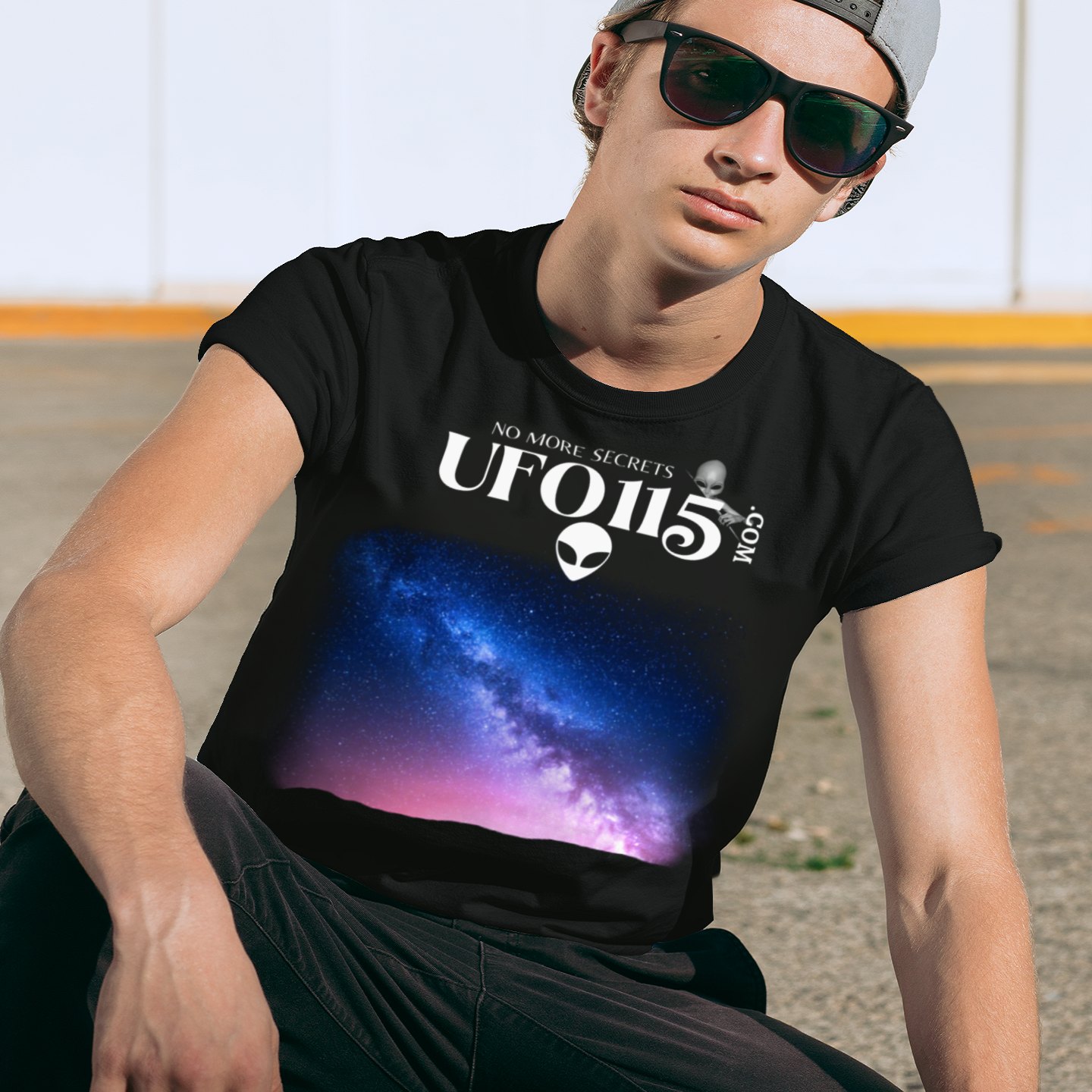 Sky Watcher Pretty in Pink T-shirt in Black, front print, worn by a model (urban crouch, day). AI-edited photo: the real print artwork was digitally placed on a model photo.