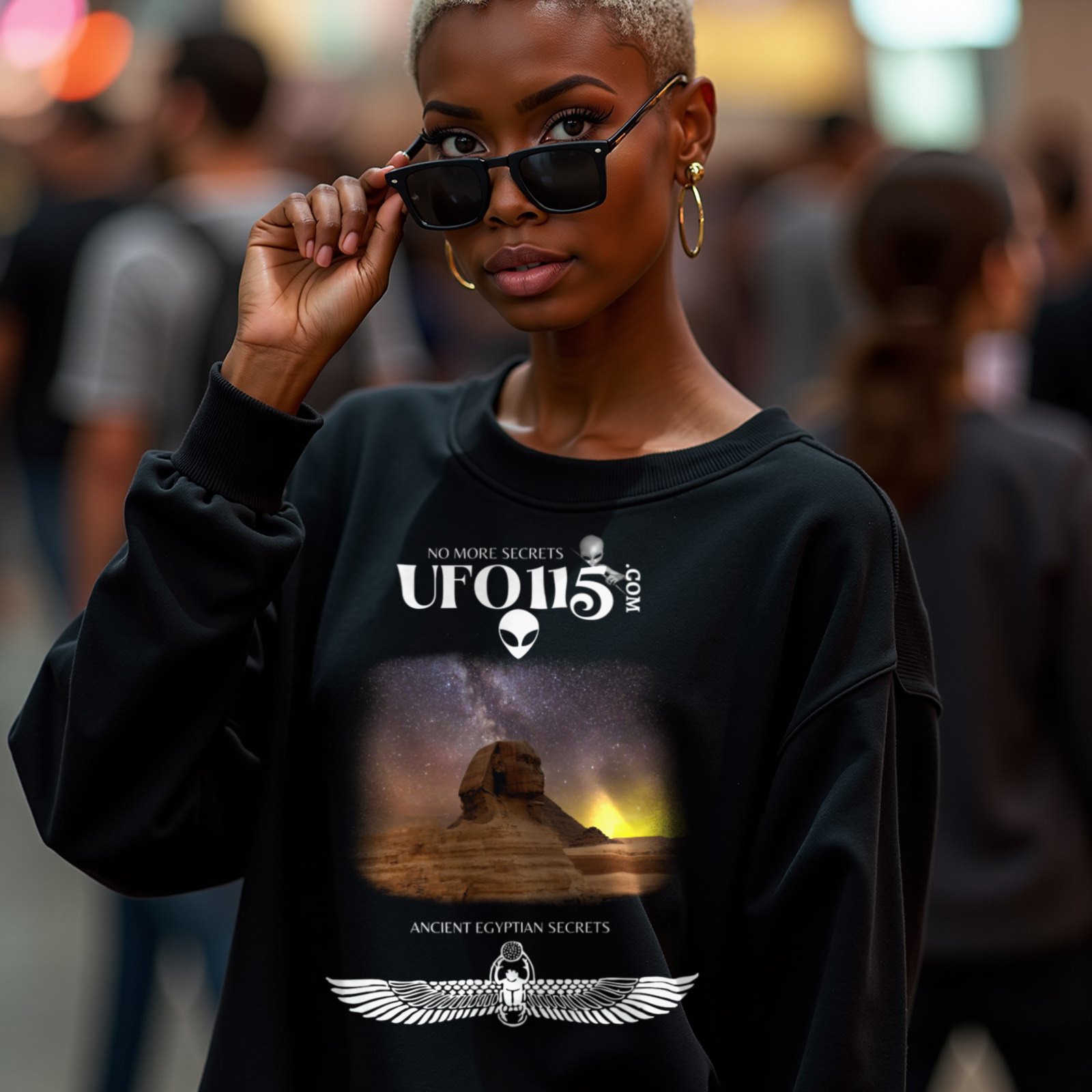 Sphinx and Sky crewneck sweatshirt in Black, worn by a model (in a busy science-fiction fan convention hall). AI-generated image: model and scene are AI-generated; the print is the real artwork.