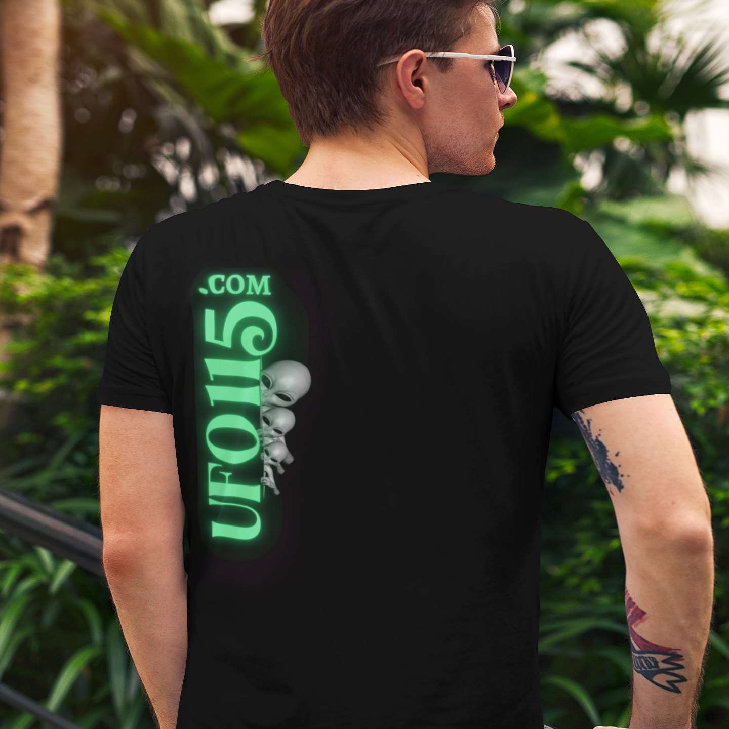 Transmedium T-shirt in Black, back print, worn by a model (tropical garden, day (back)). AI-edited photo: the real print artwork was digitally placed on a model photo.