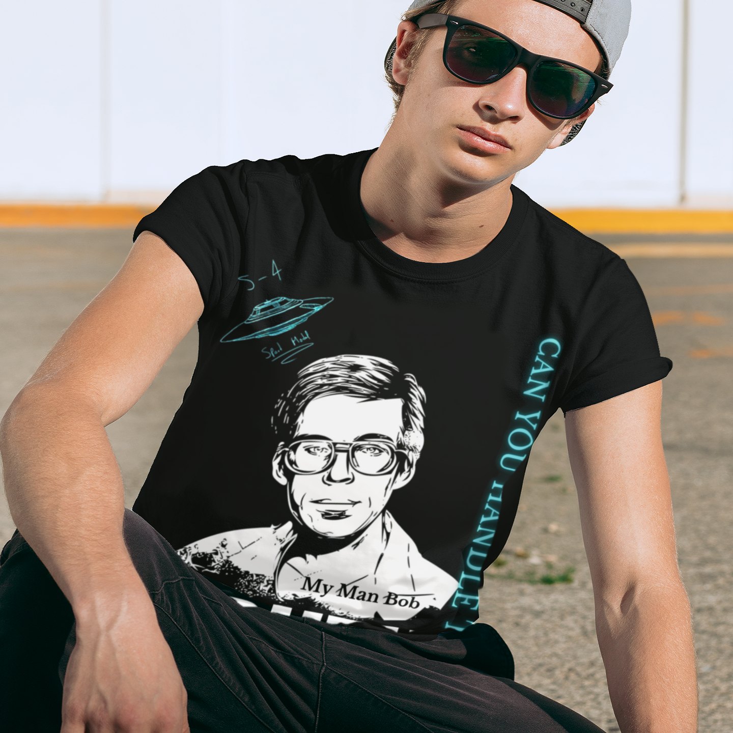 Truth Telling Bob T-shirt in Black, front print, worn by a model (urban crouch, day). AI-edited photo: the real print artwork was digitally placed on a model photo.