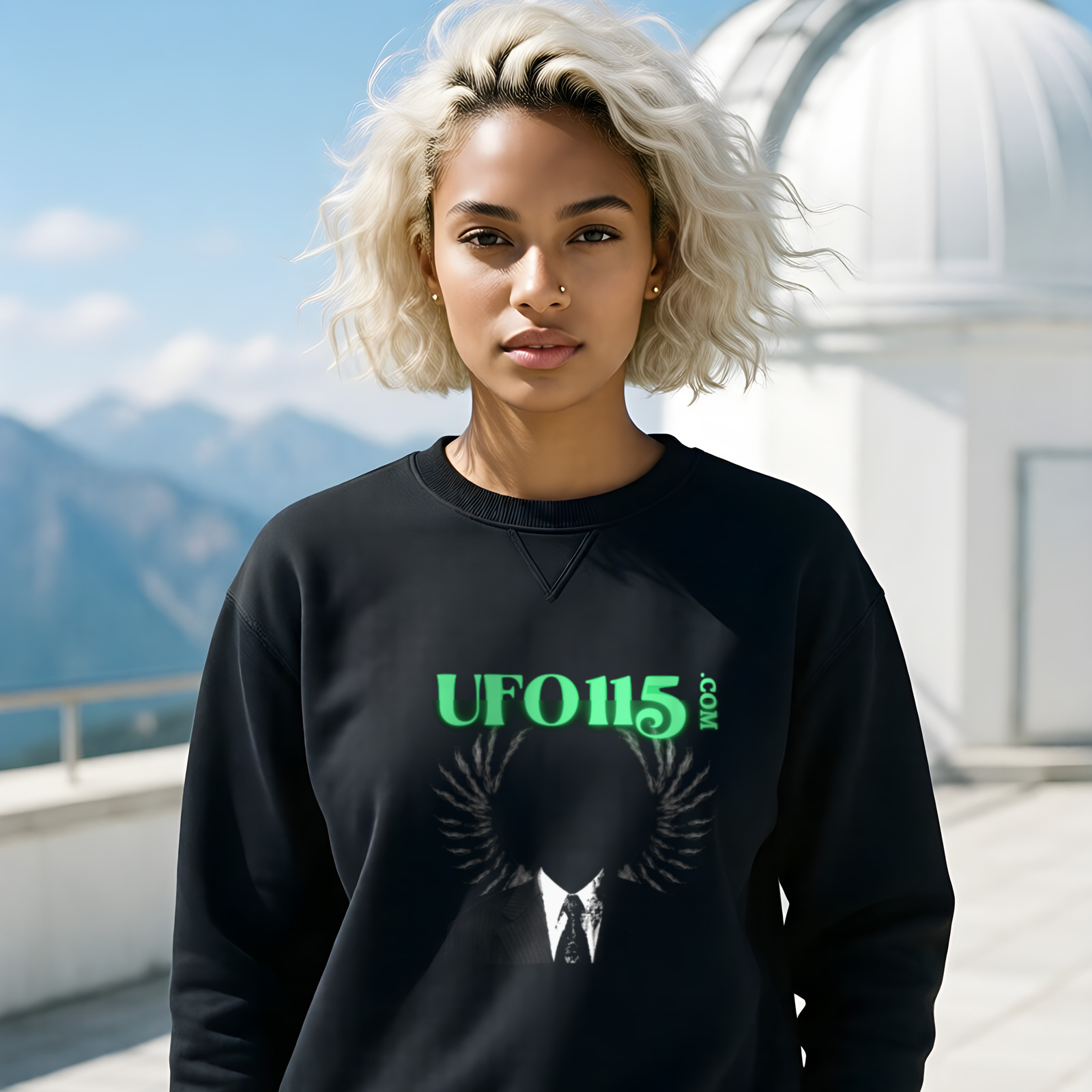 UFO115 – Green Angel crewneck sweatshirt in Black, worn by a model (on the white stone terrace of a mountain-top observatory on a bright clear day).