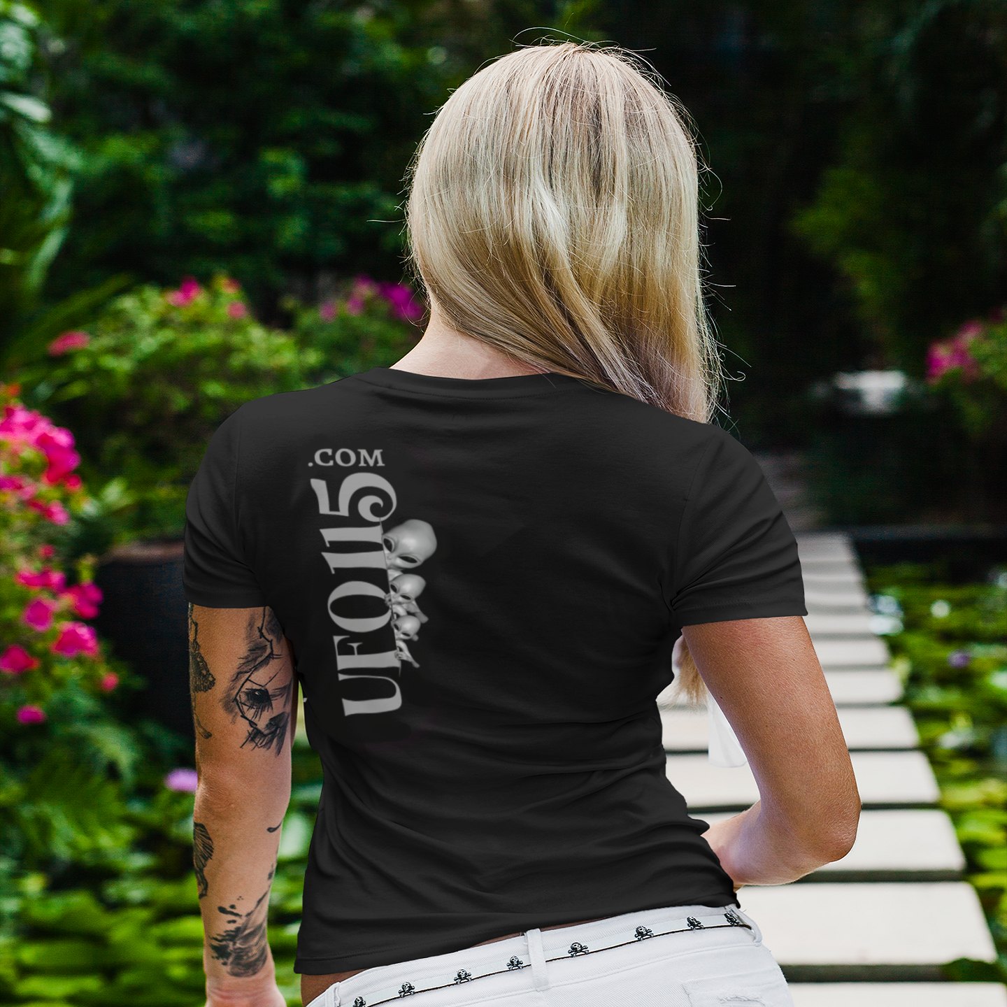 Uup 115 Entering Area 51 T-shirt in Black, back print, worn by a model (tropical garden walkway (back)). AI-edited photo: the real print artwork was digitally placed on a model photo.