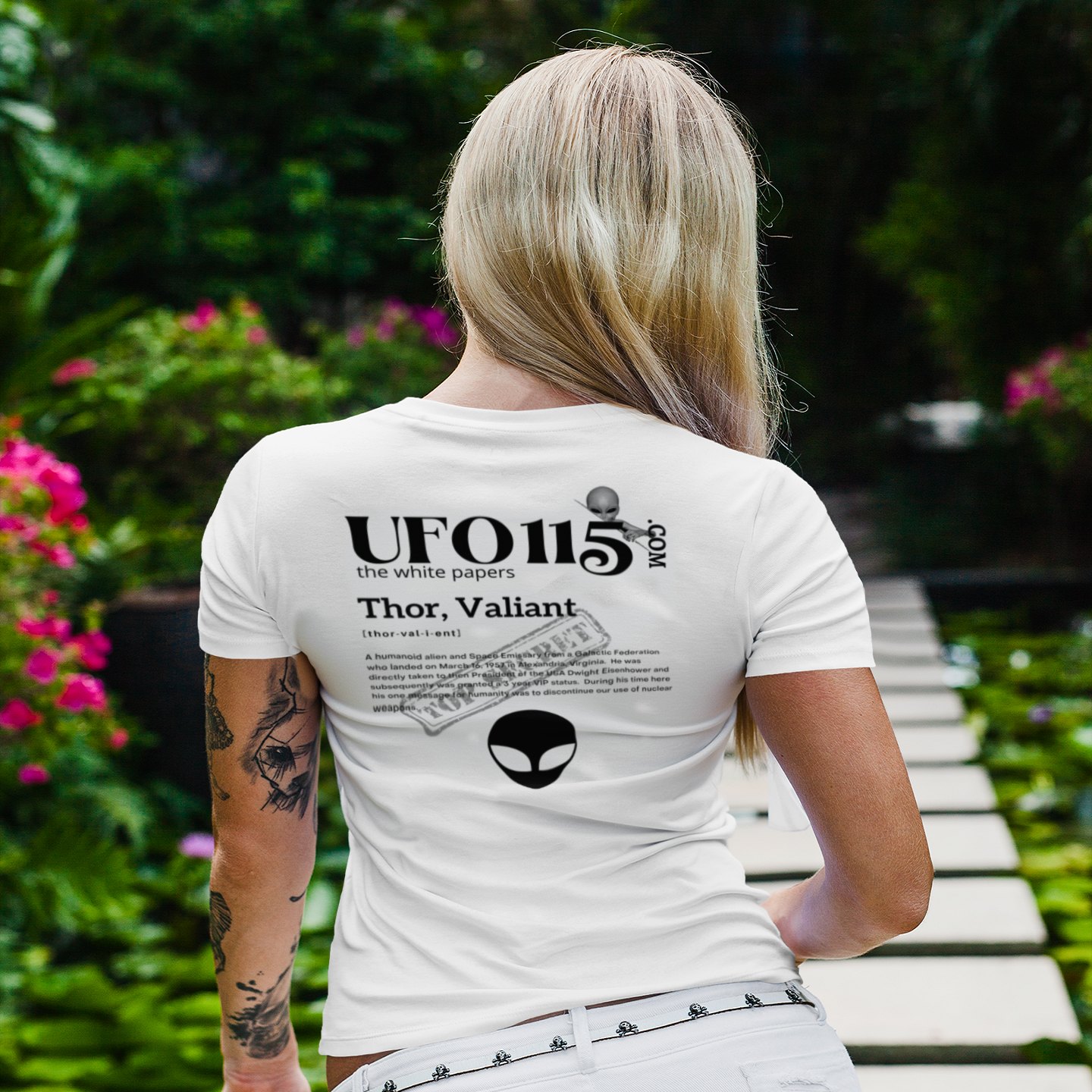 The White Papers Valiant Thor T-shirt in White, back print, worn by a model (tropical garden walkway (back)). AI-edited photo: the real print artwork was digitally placed on a model photo.