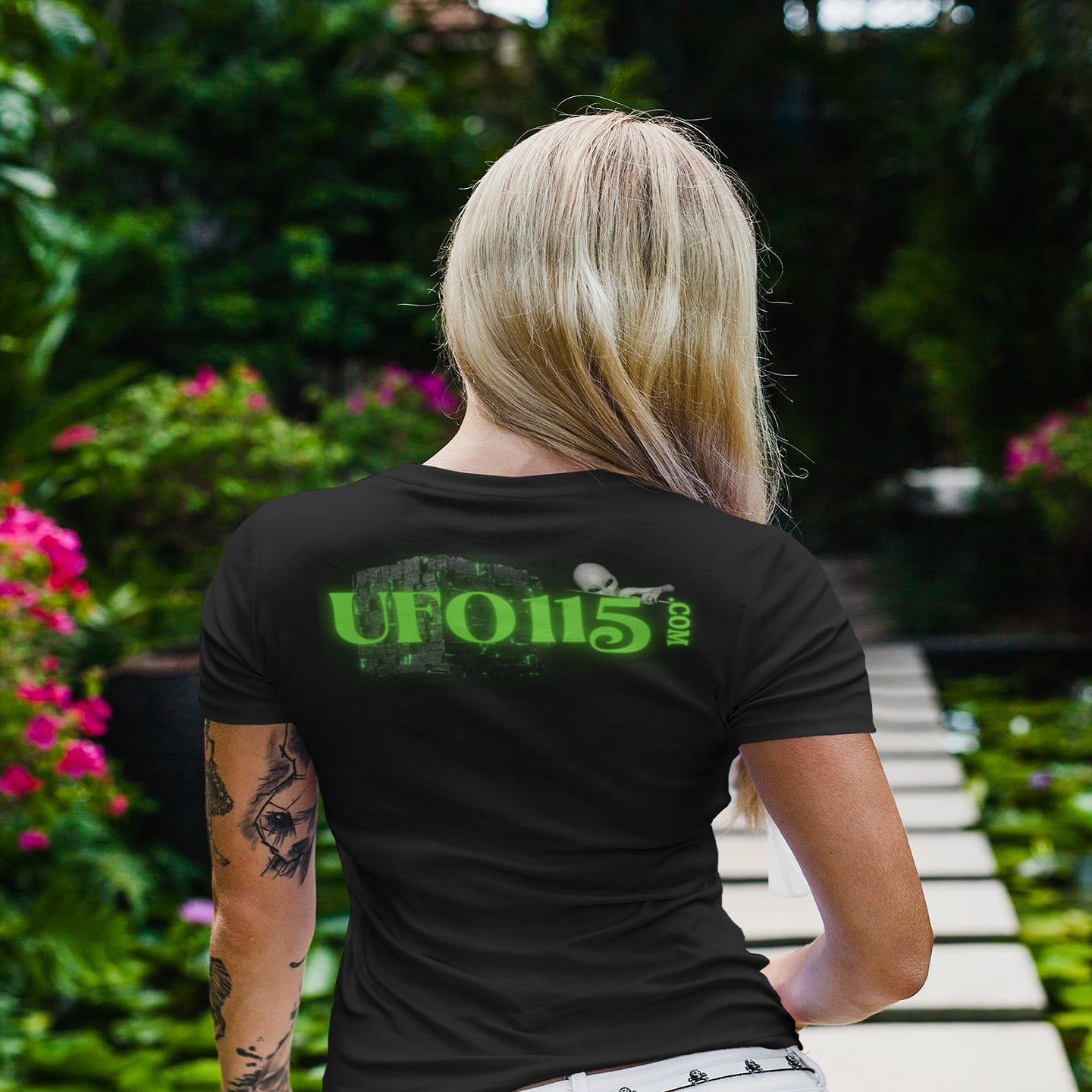 Model wearing the Government Denial Is Futile black T-shirt (back view, UFO115 back print)