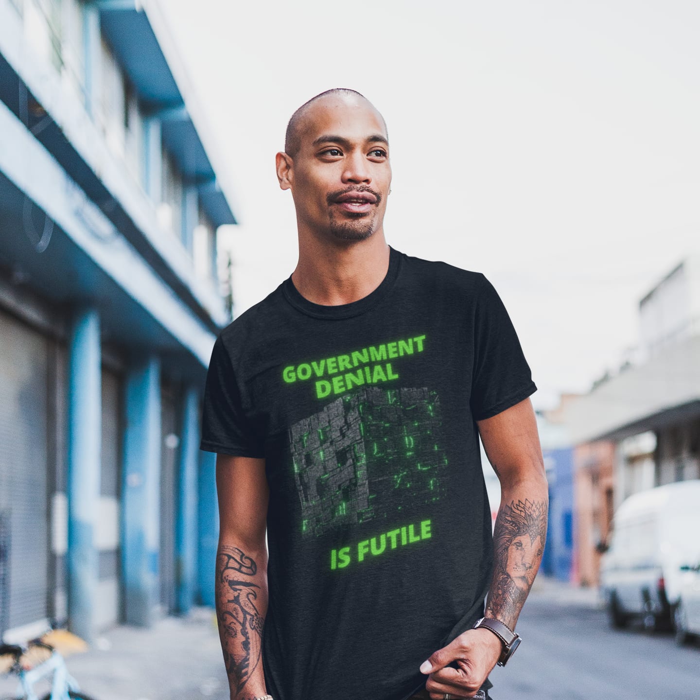 Model wearing the Government Denial Is Futile black T-shirt (front view)