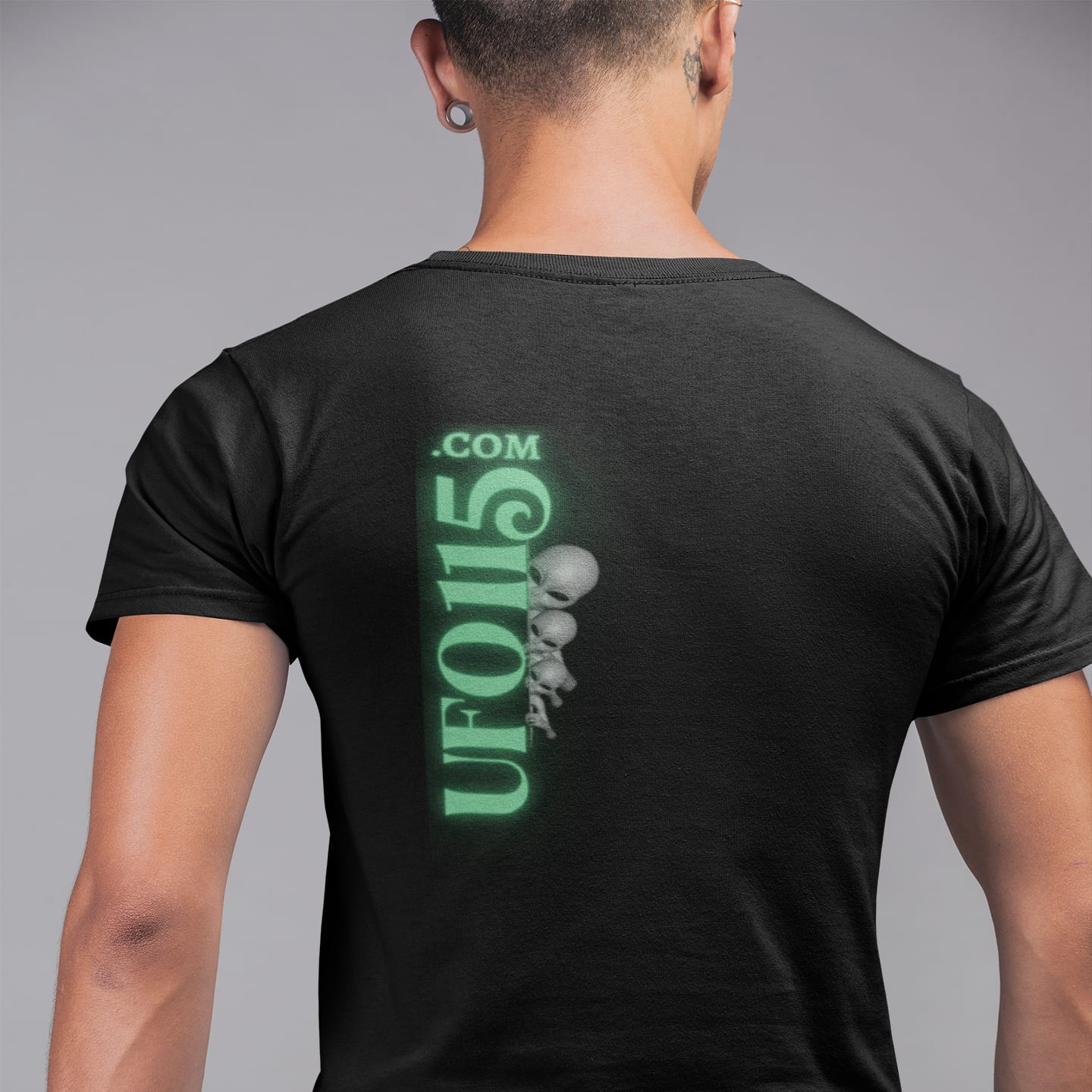 Model wearing the UFO115 Green Angel black T-shirt (back view, UFO115 back print)