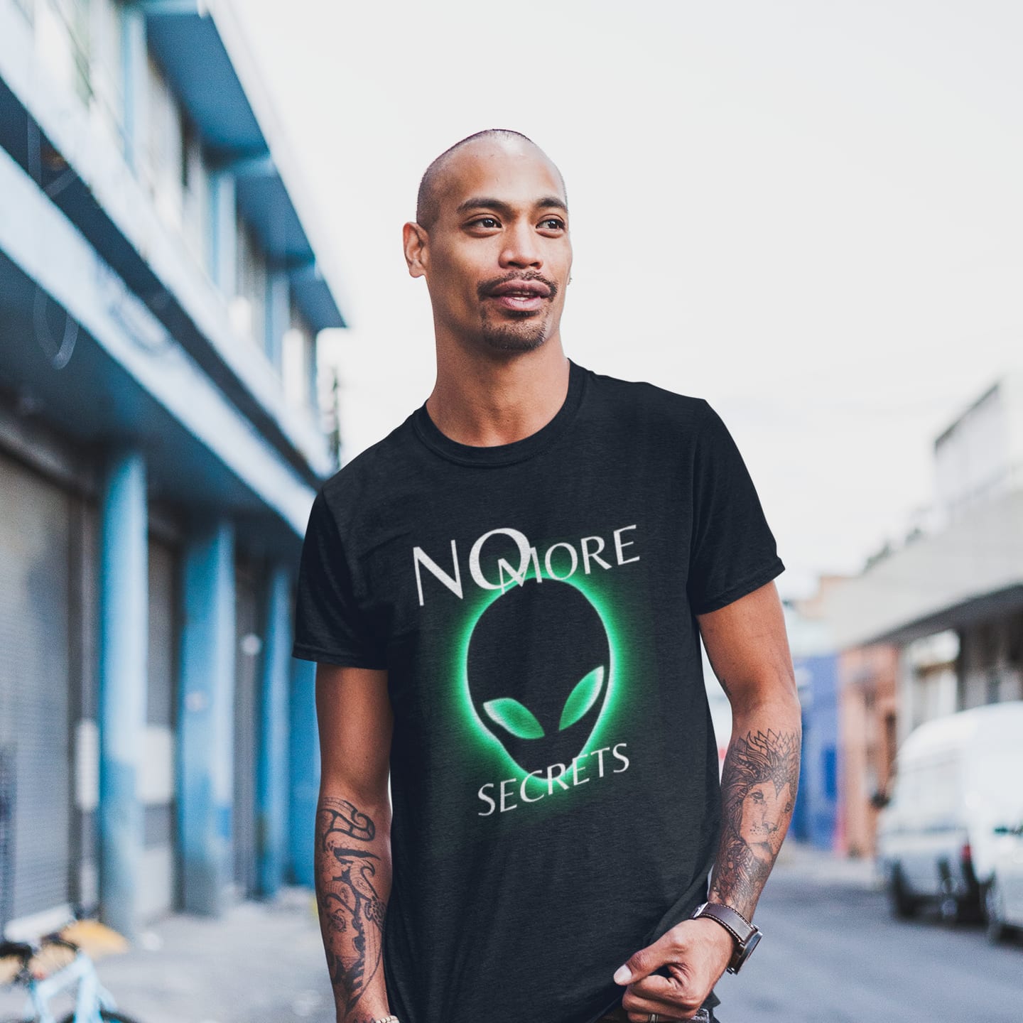 Model wearing the No More Secrets Green Glow Alien Face black T-shirt (front view)
