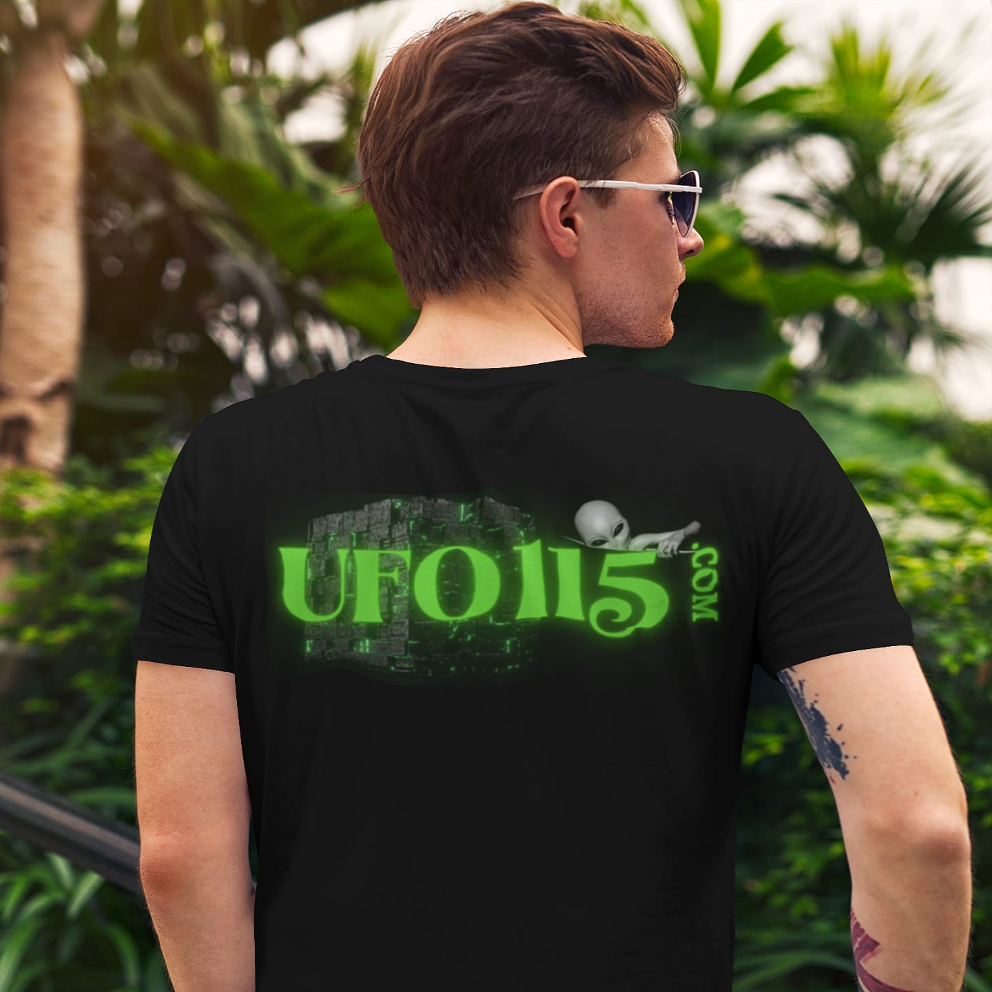 Model wearing the Government Denial Is Futile black T-shirt (back view, UFO115 back print)