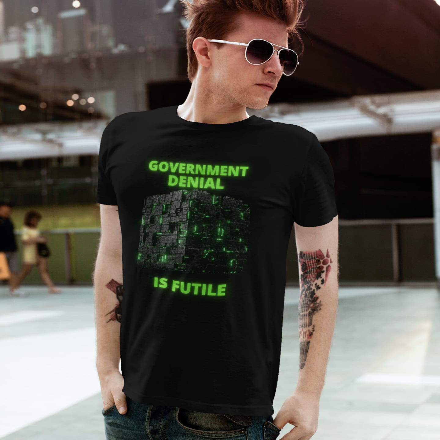 Model wearing the Government Denial Is Futile black T-shirt (front view)