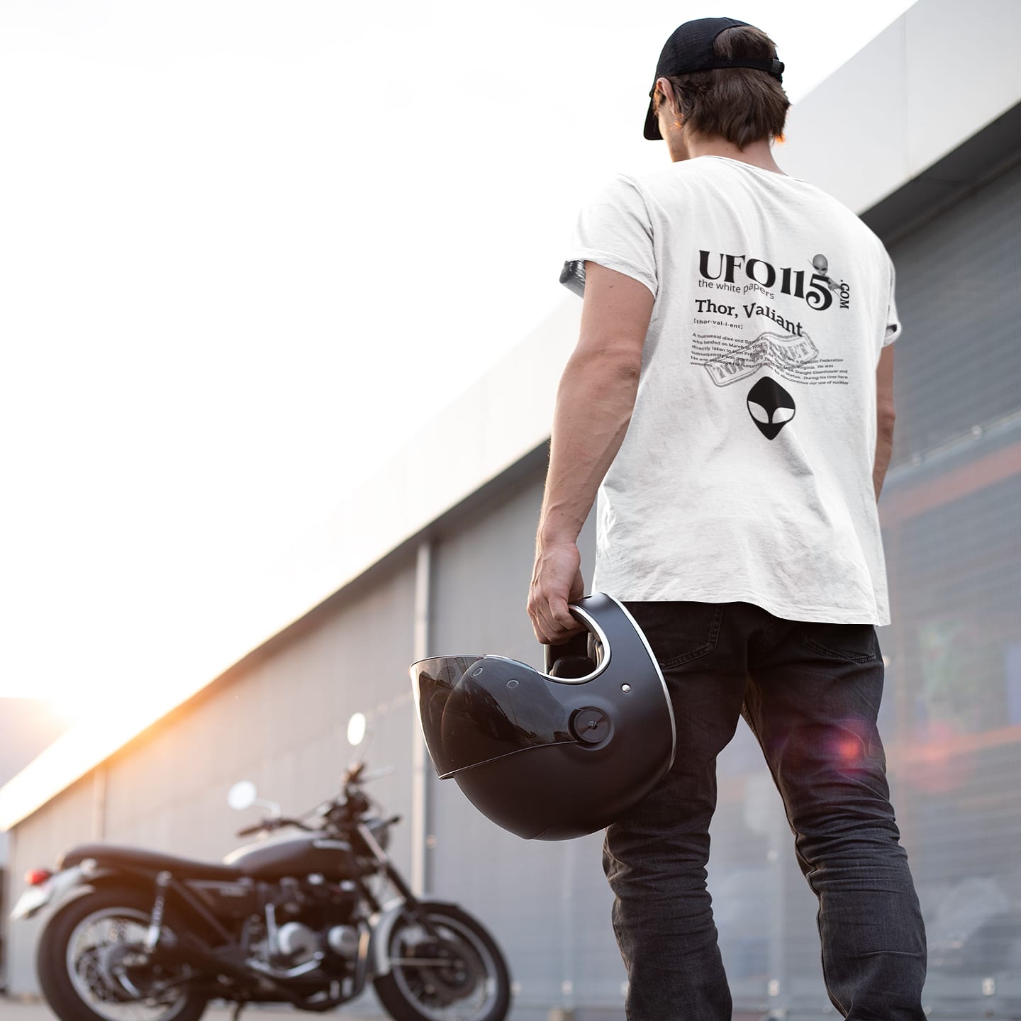 Model wearing the The White Papers Valiant Thor white T-shirt (back view, UFO115 back print)