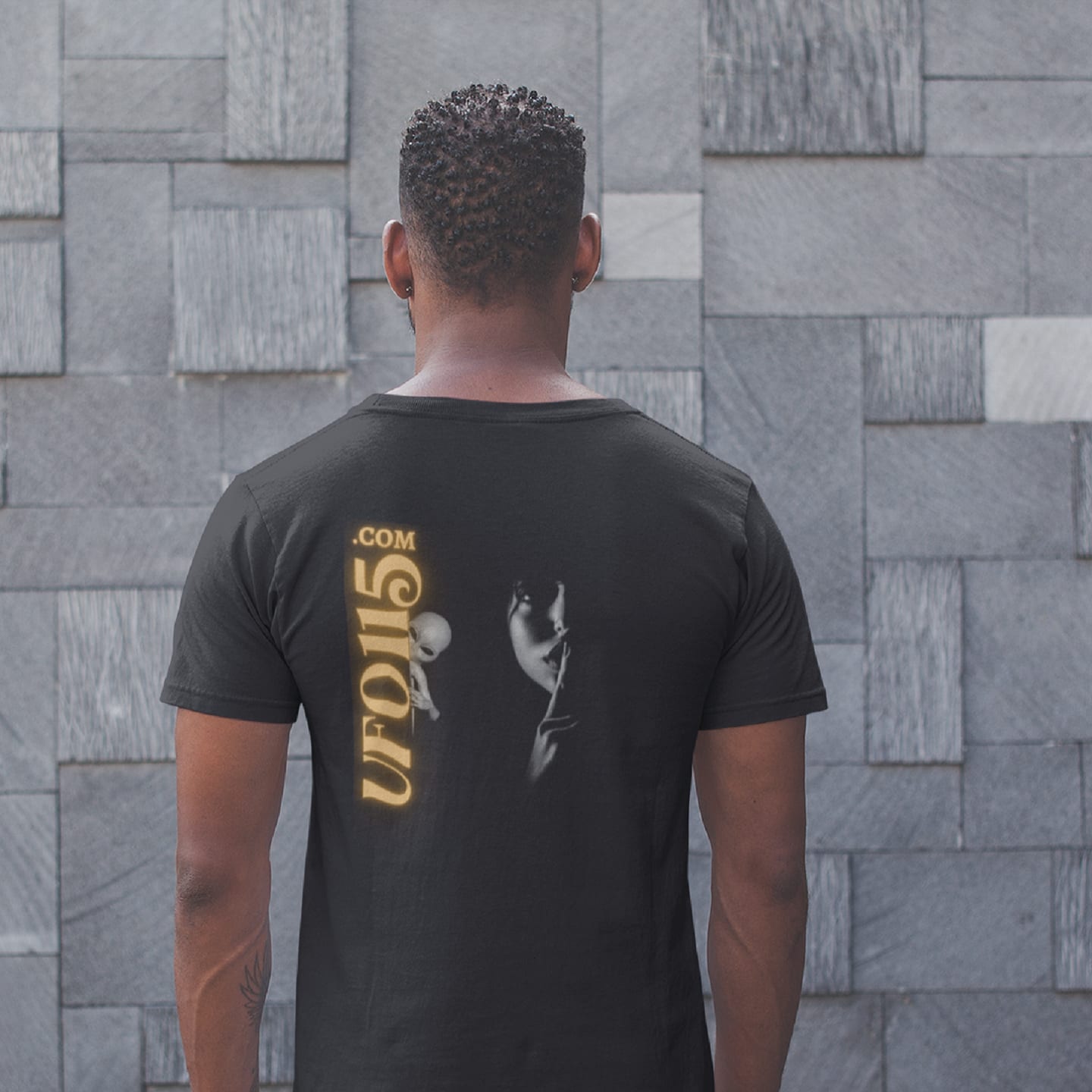 Model wearing the Uup 115 "You Never Saw Me" black T-shirt (back view, UFO115 back print)