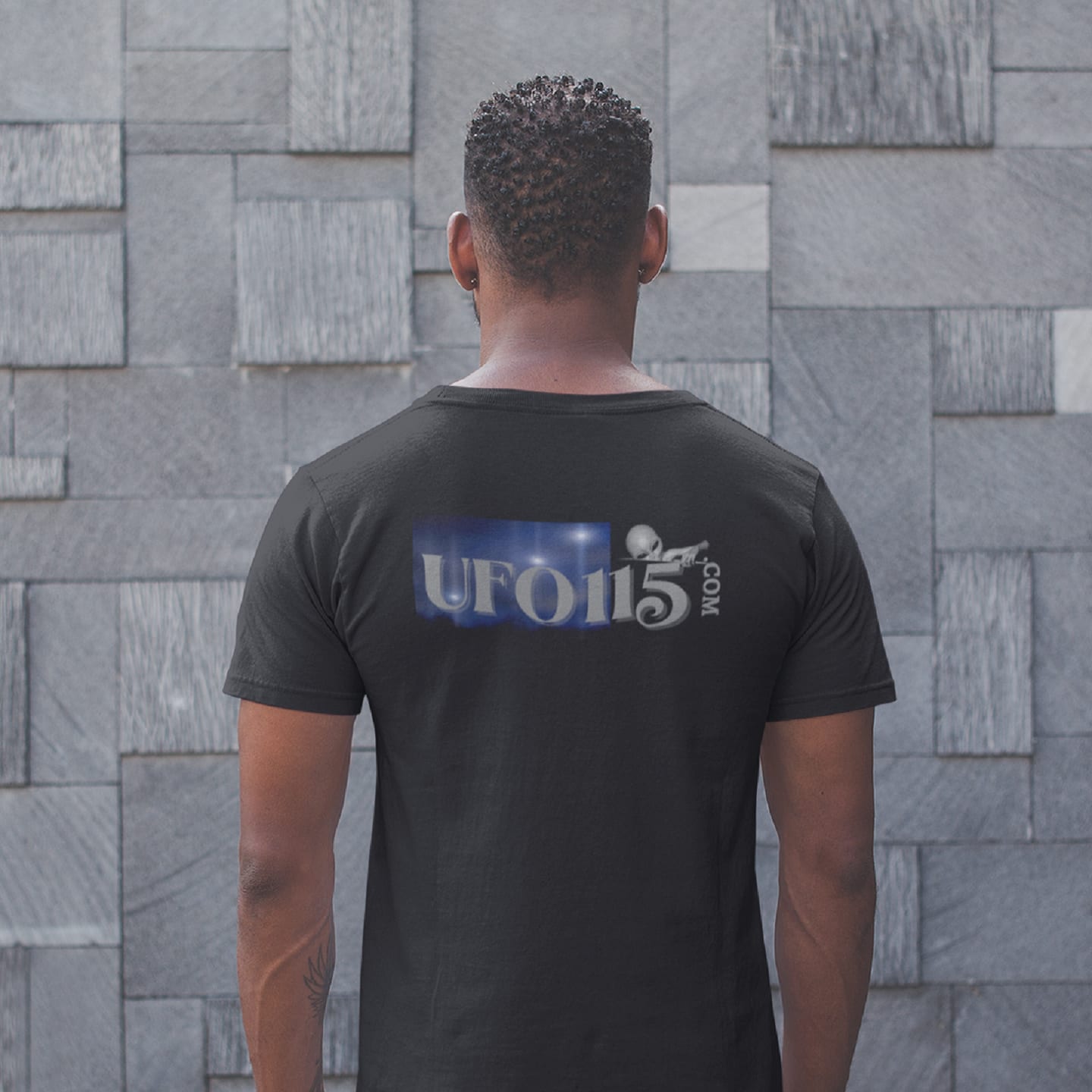Model wearing the Area 51 Black Triangle black T-shirt (back view, UFO115 back print)